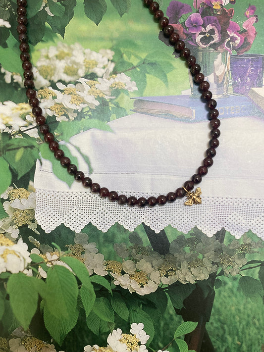 Gold bee and garnet necklace